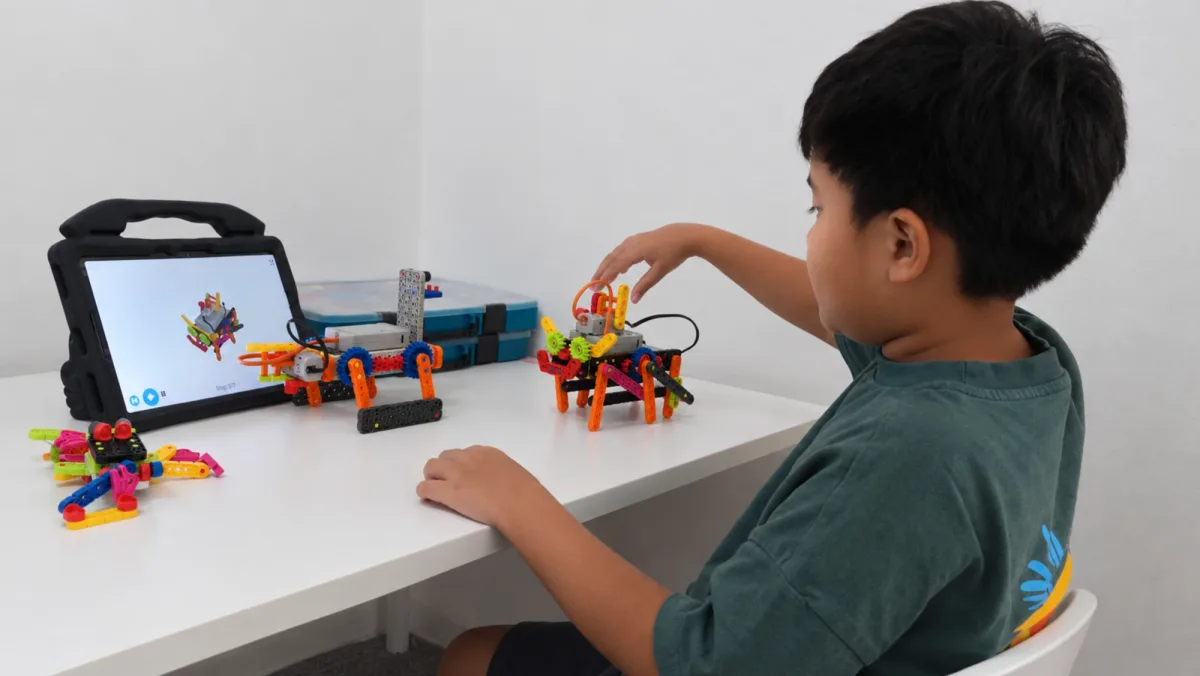 A child adjusting a VEX GO build at a white bench, with the build steps on a tablet